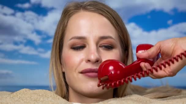 Красивая Женщина Закопанная Самую Голову Пляже Разговаривает Красному Винтажному Телефону — стоковое видео
