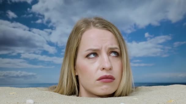 きれいな女性は彼女の周りを見てビーチで彼女の頭に埋め — ストック動画