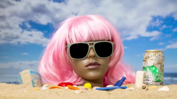 砂の中にプラスチック製の女性のマネキンの頭があり ビーチはゴミやゴミでいっぱいです — ストック動画