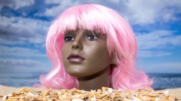 一只塑料女人体模特的脑袋卡在沙滩上 烟头堆积如山 — 图库视频影像