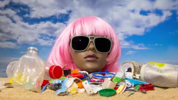 砂の中にプラスチック製の女性のマネキンの頭ゴミやゴミでいっぱいのビーチ — ストック動画