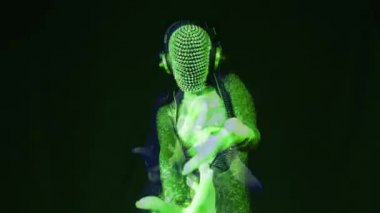 Dikenli maskeli, çarpık bir kadın dansçı.