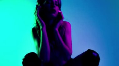 Güzel bir kadın. Kulaklıkla poz veriyor. Hipnotize edici ışık efektleri var.