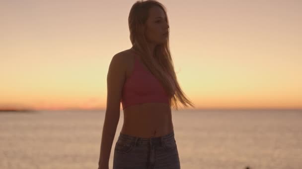 Schöne Frau Posiert Bei Sonnenaufgang Vor Glitzerndem Meer Und Himmel — Stockvideo