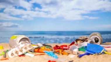 Eldivenli bir el, bir kumsalda çöp topluyor. 