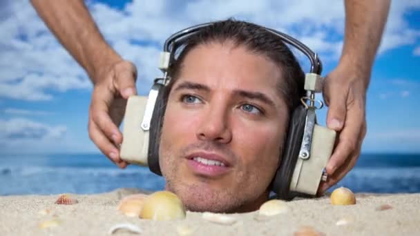 Hombre Enterrado Cabeza Una Playa Escuchando Música Con Auriculares — Vídeos de Stock