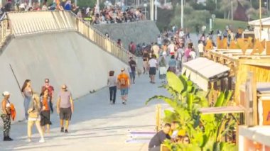 Barselona plajının yanındaki yürüyüş yolunda insanların zaman çizelgesi.