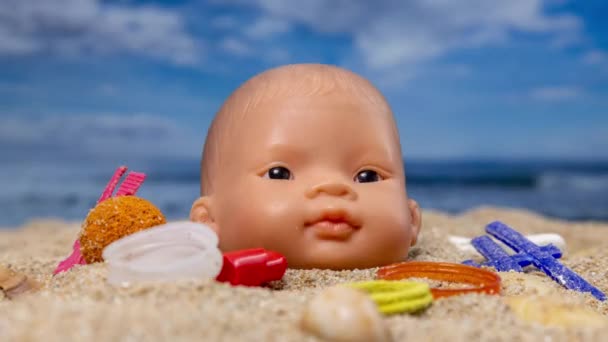 在美丽的海滩上 一个洋娃娃的脑袋被垃圾和垃圾环绕着 — 图库视频影像