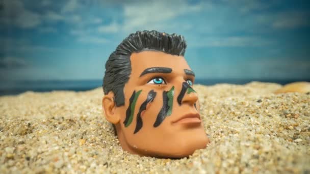 Una Muñeca Soldado Macho Cabeza Una Playa Mirando Alrededor — Vídeo de stock