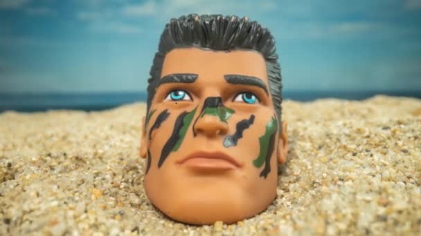 Una Muñeca Soldado Macho Cabeza Una Playa Mirando Alrededor — Vídeos de Stock