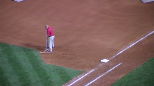 Homem Raking Baseball Infield — Vídeo de Stock