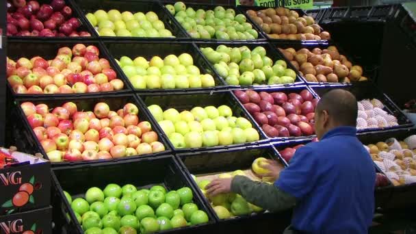 Mens geconfronteerd met appels in producten — Stockvideo