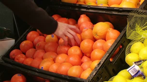 Mulher selecionando laranjas em produzir — Vídeo de Stock