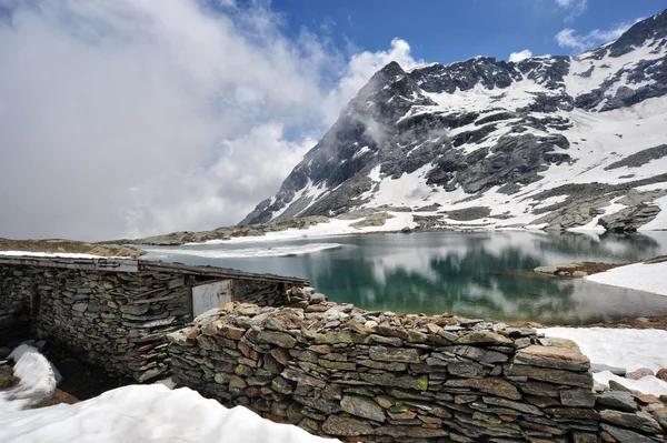 Высокие горные пейзажи с озером и снегом — стоковое фото