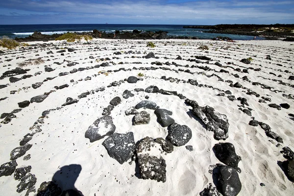 Spirale aus schwarzen Felsen am weißen Strand von Lanzarote — Stockfoto