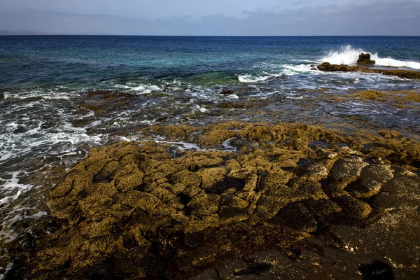 Taş taş gökyüzü bulut plaj su lanzarote İspanya — Stok fotoğraf