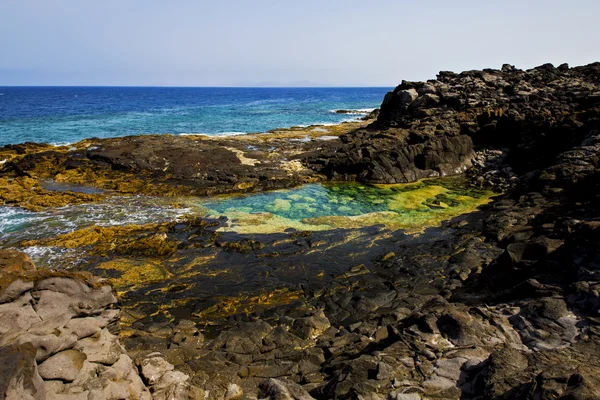 Liggande sten himlen moln klippstrand — Stockfoto