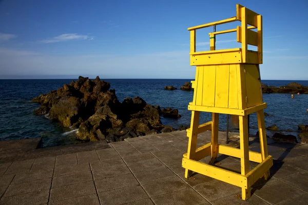 Gelbe Rettungsschwimmstuhlkabine in Spanien Stein Himmel Wolke b — Stockfoto