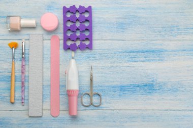 Mavi arka planda manikür ve pedikür için çeşitli aletler. Yukarıdan görünüm.