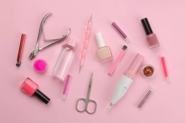 Pembe arka planda manikür ve pedikür için çeşitli aletler. Yukarıdan bak. tırnak bakımı.