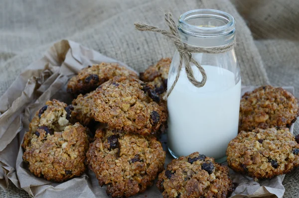Biscoitos de aveia e garrafa de leite sobre fundo de lona — Fotografia de Stock