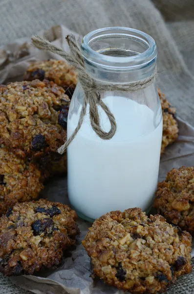 Havermout cookies en fles melk op doek achtergrond — Stockfoto