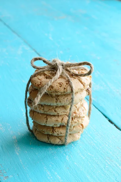 Pile of homemade meringue bounded up with ribbon and bow on blue — Stock Photo, Image