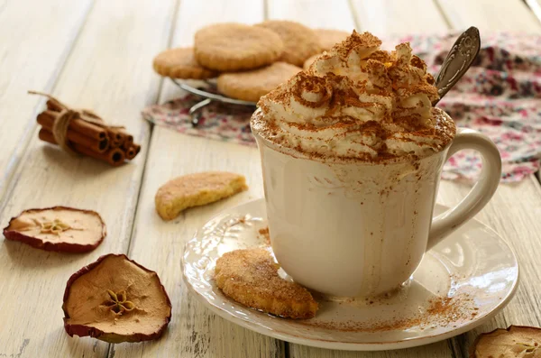 Xícara de café chantilly e biscoitos de maçã na mesa de madeira — Fotografia de Stock