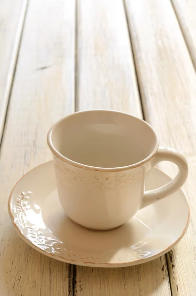 Empty coffee cup of creamy color on wooden table — Stock Photo, Image