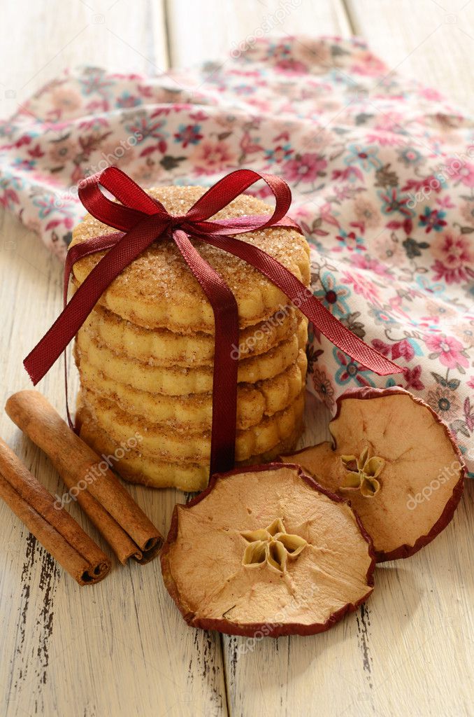 Pile of apple cookies tied up with ribbon and bow on wooden tabl