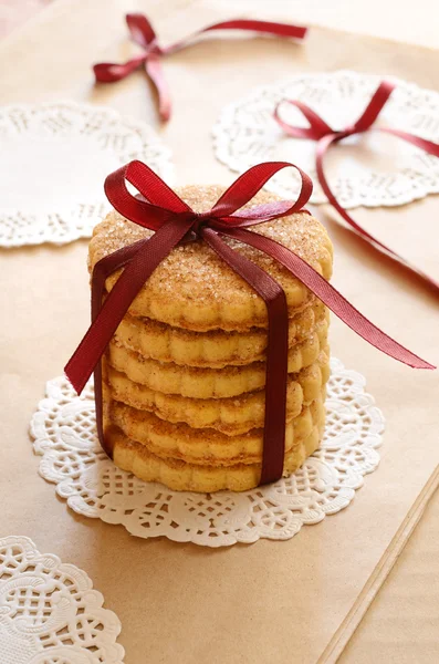 Galletas atadas con cinta y lazo sobre fondo marrón claro — Foto de Stock