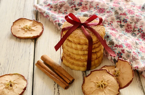 Mucchio di biscotti di mele legati con nastro e fiocco su tavola di legno — Foto Stock