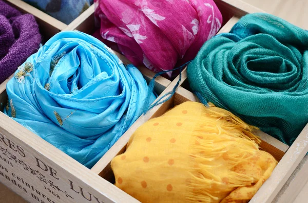 Conjunto de bufandas de colores en caja de madera Imagen de stock