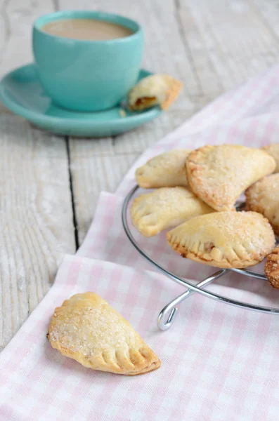 Söt liten pajer och en kopp kaffe med mjölk på shabby trä t — Stockfoto