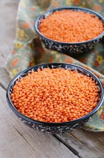 Oriental bowls with red lentils on wooden background — Stock Photo, Image