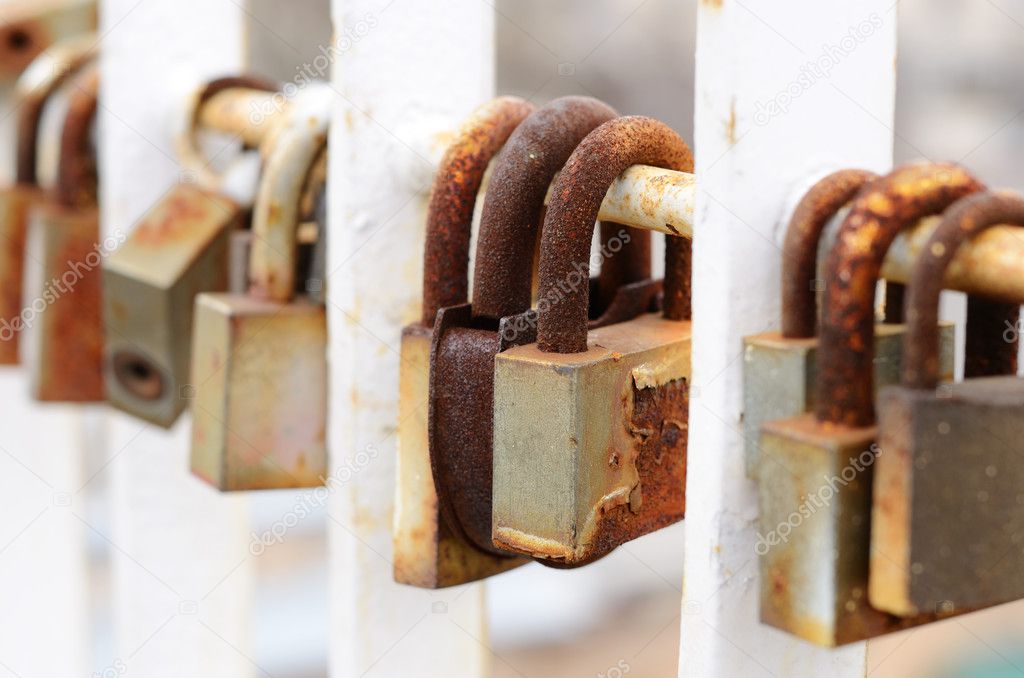 Old padlocks hanging on the metal fence