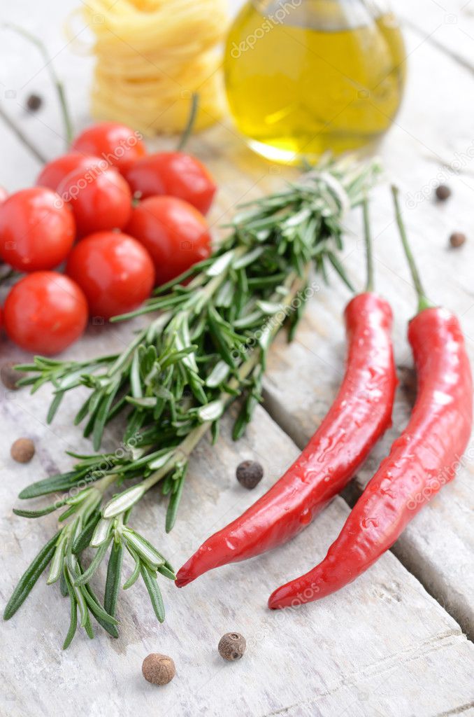 Italian ingredients - rosemary, olive oil, chilli, tomatoes, raw