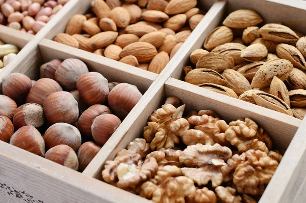 Matice mix v dřevěné krabici - ořech, mandlí, lískových oříšků, kešu a hrášek — Stock fotografie