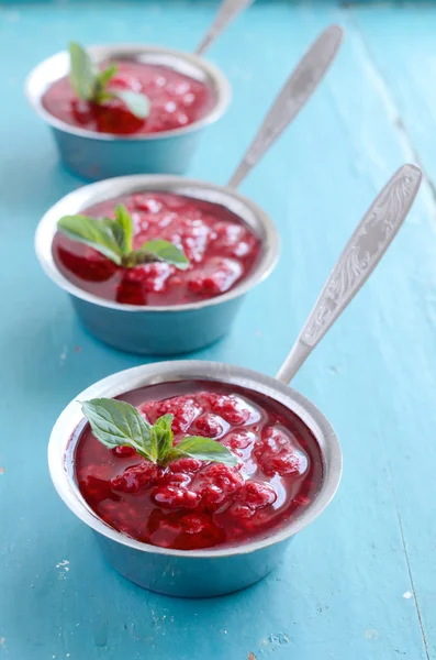 Homemade raspberry topping topped with fresh mint leaves — Stock Photo, Image