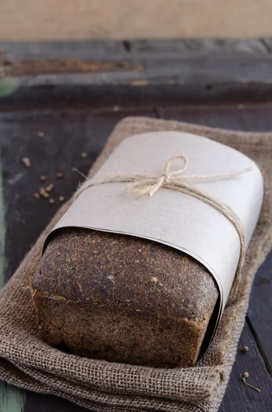 Čerstvý žitný chléb na dřevěném pozadí — Stock fotografie