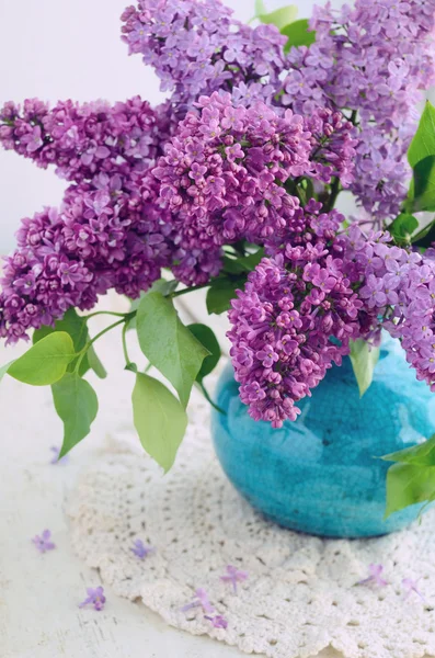 Hermosas flores de color lila en florero turquesa —  Fotos de Stock