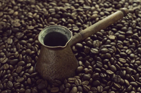Винтажный кофе cezve на фоне кофейных зерен — стоковое фото