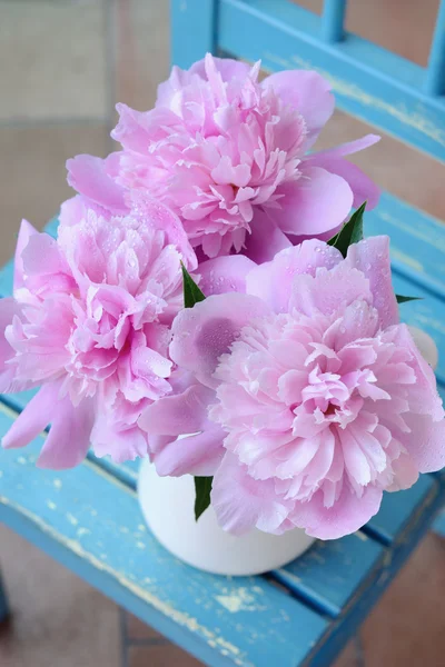 Bunch of peony on shabby blue chair — Stock Photo, Image