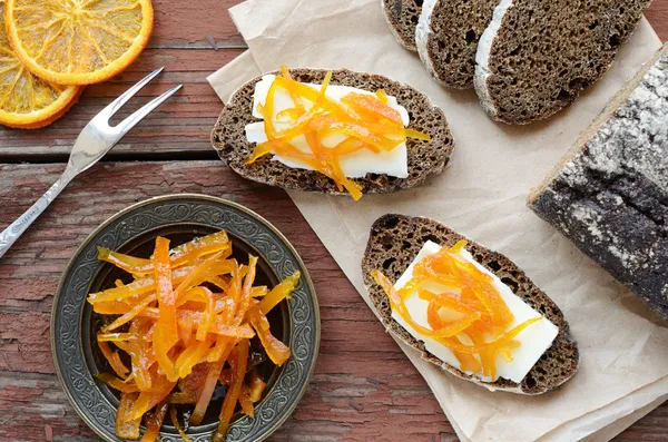 Roggebrood met boter en zelfgemaakte oranje confiture op verroeste wo — Stockfoto