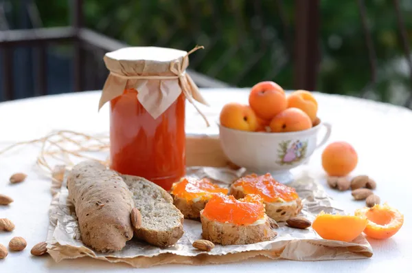 Breakfast with apricot jam, bread, fresh apricots and almonds — Stock Photo, Image