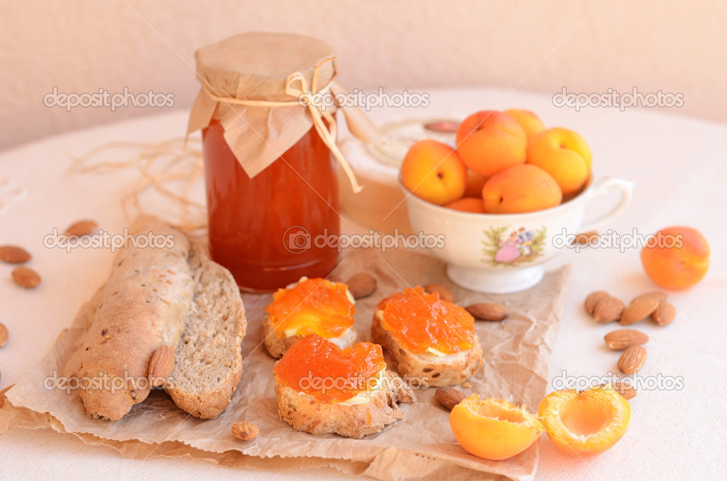 Breakfast with apricot jam, bread, fresh apricots and almonds
