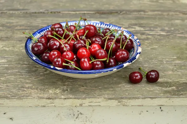 Sweet cherry in blue oriental bowl — Stock Photo, Image
