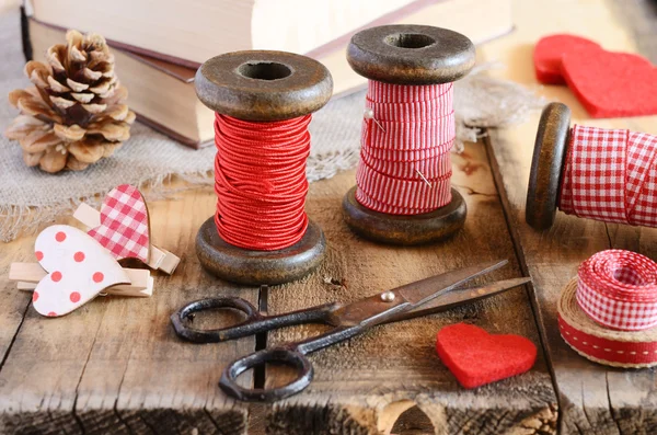 Decoration with wooden spools and red ribbons — Stock Photo, Image