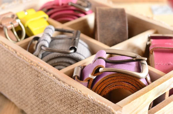 Verzameling van stijlvolle gordels in houten kist — Stockfoto
