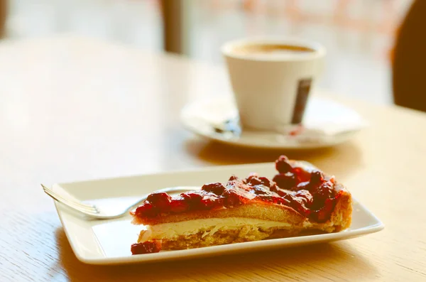 Кусок клубничного пирога и чашка эспрессо в кафе — стоковое фото